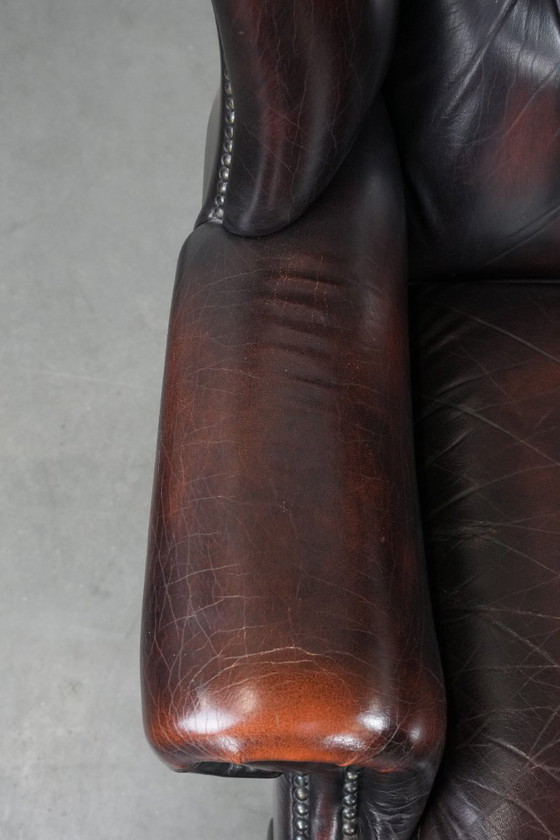 Image 1 of Poltrona Chesterfield con braccioli in pelle bovina marrone, in classico stile inglese.