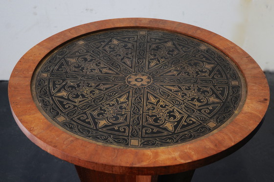 Image 1 of Una mesa para fumar Art Decó con una tapa de latón decorada.