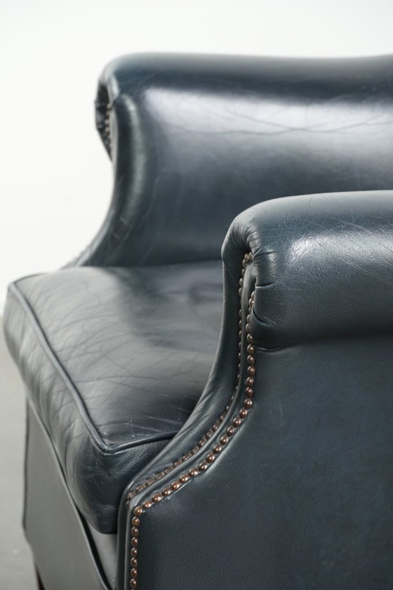 Image 1 of Bellissima e confortevole poltrona club in pelle bovina blu scuro dal design unico e senza tempo.