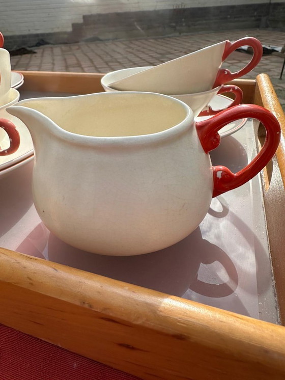 Image 1 of Set van 7 aardewerken kopjes, 5 schotels en 1 melkkan. Gemerkt met afbeelding van een springend hert en het woord 'Holland'.    