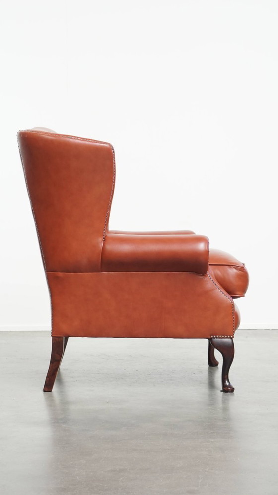 Image 1 of Elegante en comfortabele gladde Engelse rundleren chesterfield oorfauteuil met sierlijke pootjes