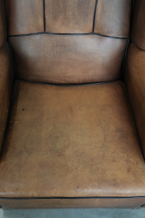 Image 1 of Poltrona a orecchioni in pelle di pecora con profili neri, in buone condizioni.