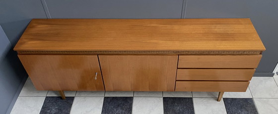 Image 1 of Dressoir uit de jaren 70 met decoratieve lijn boven de deuren.