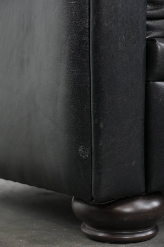 Image 1 of Set van een zwarte rundleren chesterfield fauteuil en hocker