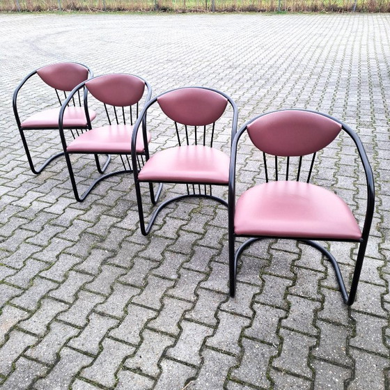Image 1 of This is a set of four vintage 'Memphis' style chairs with a black metal frame and burgundy upholstery.