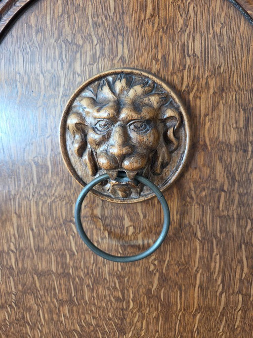 Antique oak cabinet with lion heads