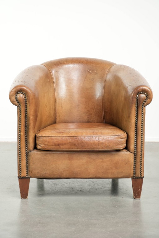 Sillón club vintage de piel de oveja con hermosos colores y acabado con clavos decorativos.