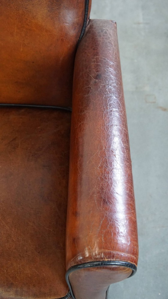 Image 1 of 4 x Vintage schapenleren eetkamerstoel met zwarte biezen op wieltjes