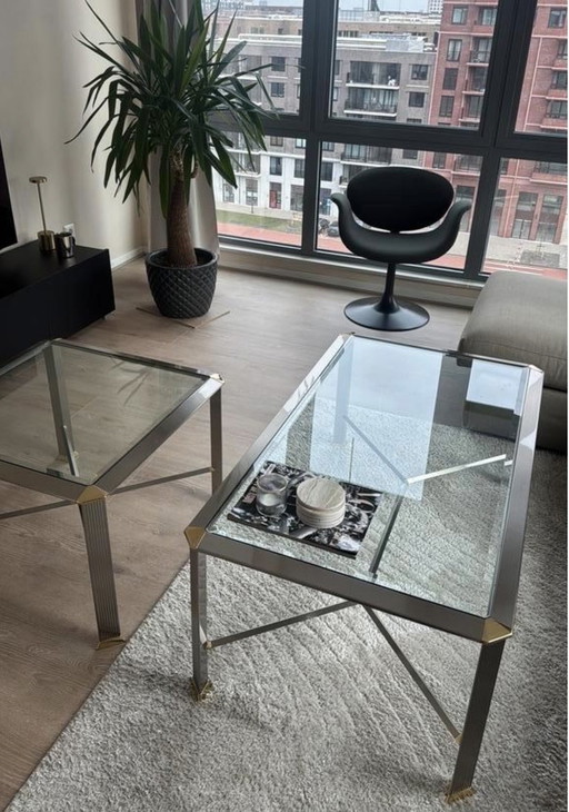 Dos mesas de centro de cristal plateado/dorado