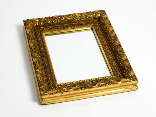 Espejo de pared de mediados de siglo de Italia con un marco de madera adornado y bañado en oro.