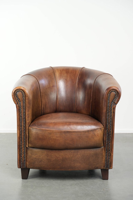 Sturdy and characterful sheepskin club armchair with a beautiful patina, finished with decorative nails. (photo 2 of 12)