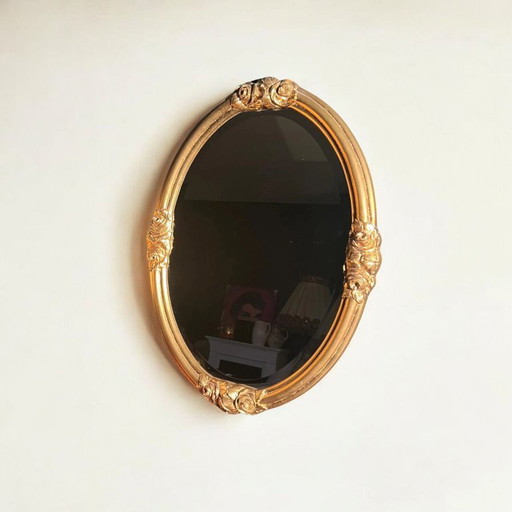 Oval Art Nouveau / Art Déco mirror with facet cut. Original vintage with golden frame and rose decoration.