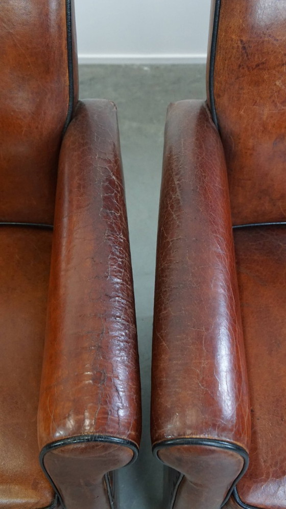 Image 1 of 4 x Vintage schapenleren eetkamerstoel met zwarte biezen op wieltjes