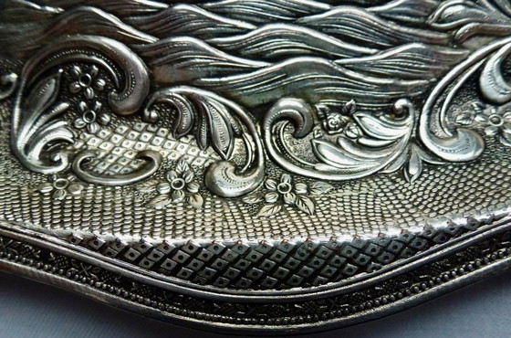Image 1 of Decoratief verzilverde schaal met een gedetailleerde reliëfvoorstelling.