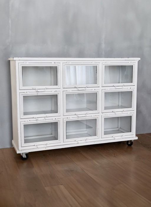 Vintage metal display case with 9 glass swinging doors.