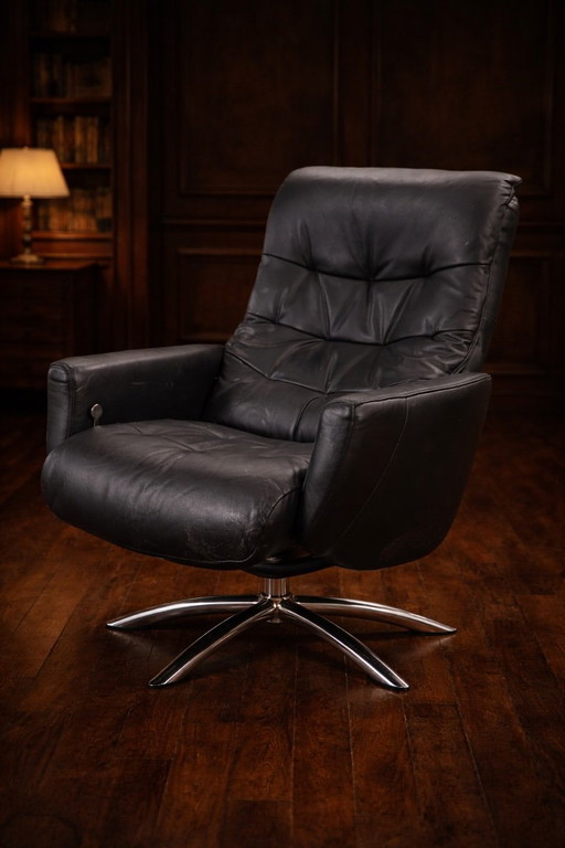 Modernist black leather armchair with a chrome X-frame base in a contemporary style, in good condition with minor signs of aging