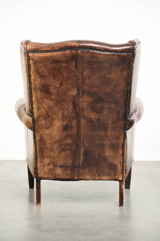 Ruime vintage schapenleren oorfauteuil in een diepe bruine kleur afgewerkt met siernagels – Leather (photo 4 of 17)