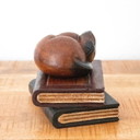 Figura de teca de un gato durmiendo sobre dos libros.