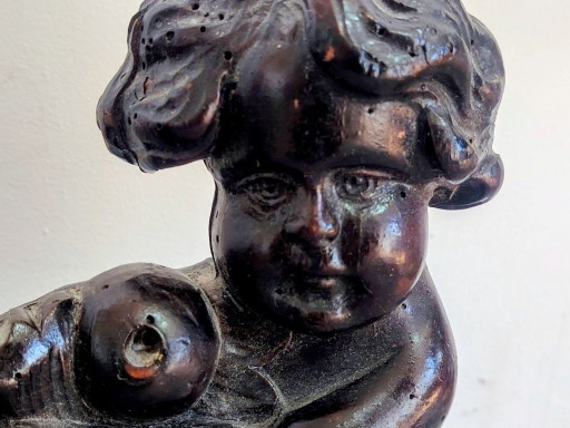 Panneau ancien en bois sculpté représentant un chérubin.
