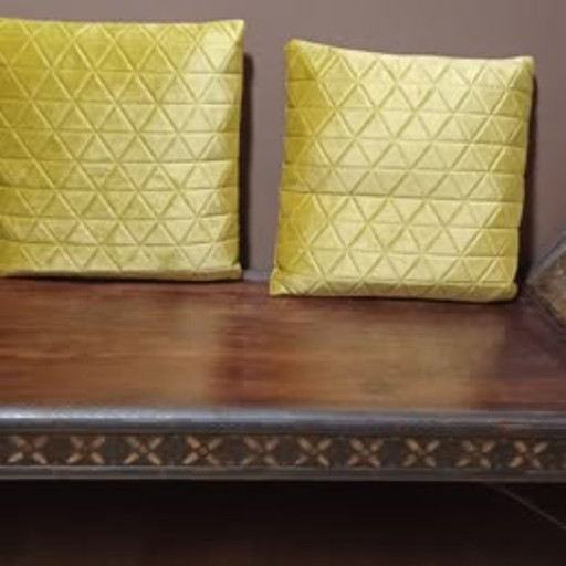 Banc en bois foncé avec incrustations et coussins jaunes