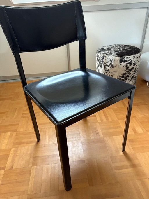 6 (eventueel 8) onverwoestbare Italiaans design eetkamerstoelen, zwart tuigleer, stalen constructie. Afmetingen: hoog 82, zittin