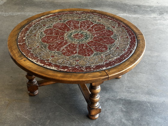 Brutalistische ronde salontafel van hout en veelkleurig leer met dierenriemdecoratie. – Wood, Leather (photo 4 of 12)