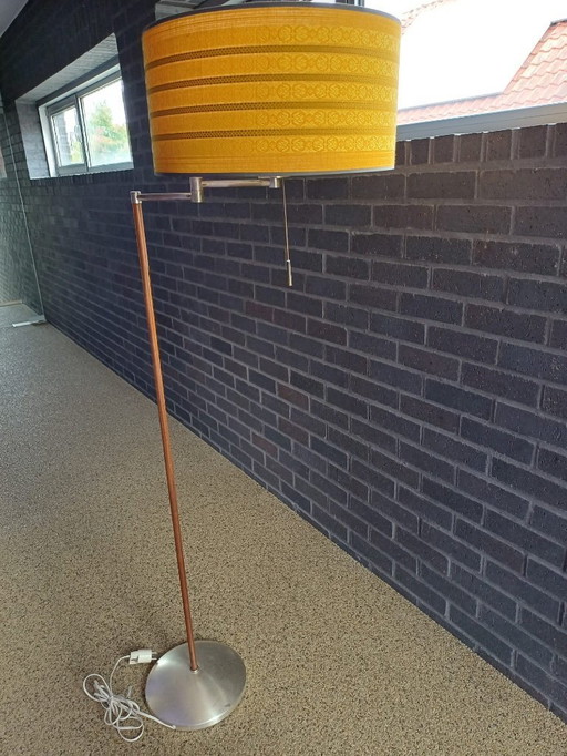 Se trata de una lámpara de pie moderna de nogal de mediados de siglo con una pantalla de tela de color amarillo ocre.