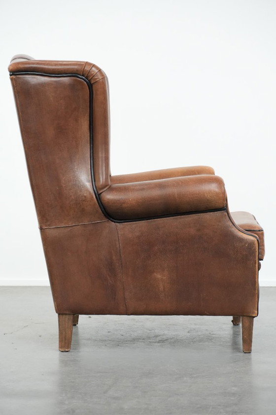 Image 1 of Poltrona a orecchioni in pelle di pecora con profili neri, in buone condizioni.