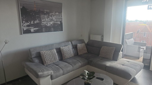 Sofá esquinero moderno blanco/gris con aspecto de piel y tela.