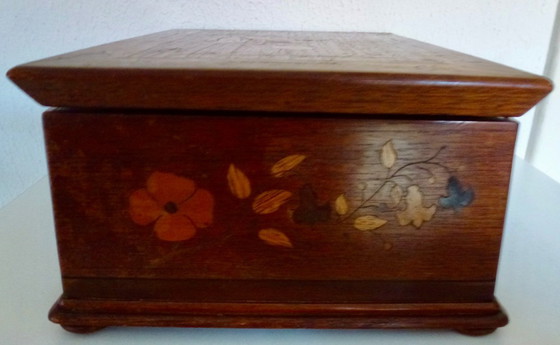 Image 1 of Una scatola di legno d'epoca con intarsi floreali
