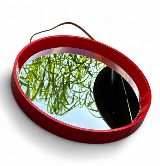 ronde Retro rood muur spiegel in hard Plastic en met lederen riem te hangen. IKEA ontwerp begin jaren 1970