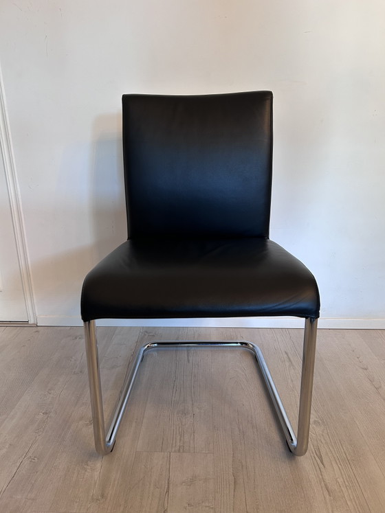 Image 1 of Ensemble de salle à manger Hülsta D2 – table à manger en verre avec 4 chaises en cuir noir à piètement luge