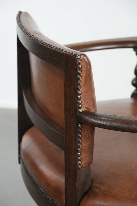 Image 1 of Elegante antieke schapenleren bureaustoel met een zwaar houten frame