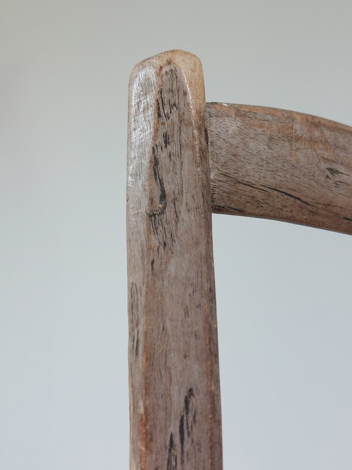 Silla antigua de madera de estilo folclórico francés con pátina y tejido de cuerda.