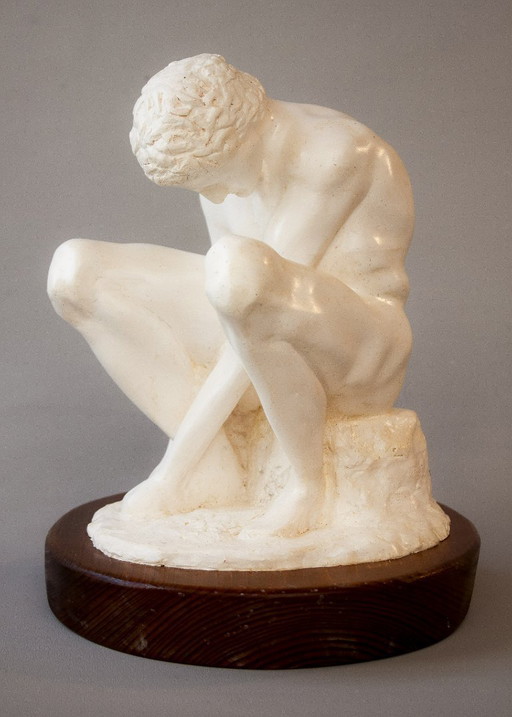 Sculpture of a seated man. Classical male sculpture. Male figure.
