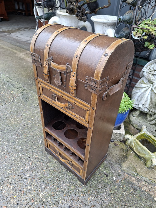 Precioso botellero revestido de cuero, con tapa superior, dimensiones: 50 x 25 cm y 79 cm de alto.