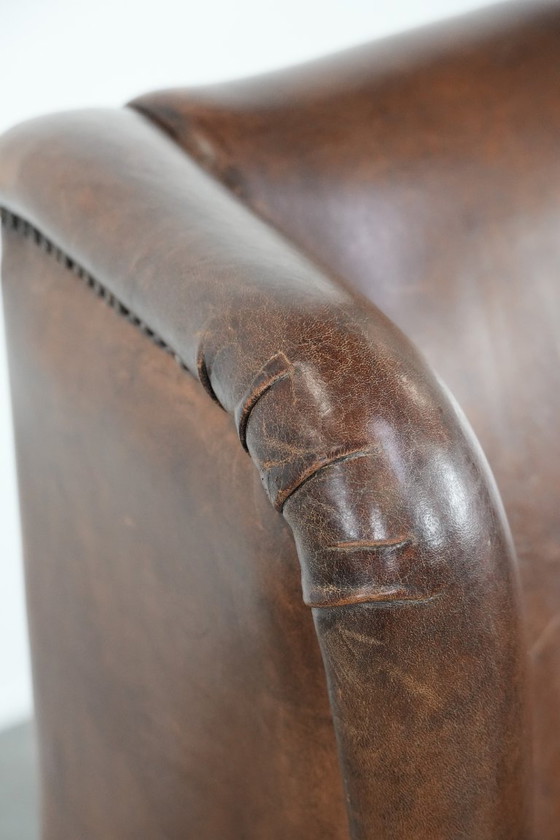 Image 1 of Caratteristica poltrona vintage di grandi dimensioni con ali laterali, realizzata in pelle di pecora.