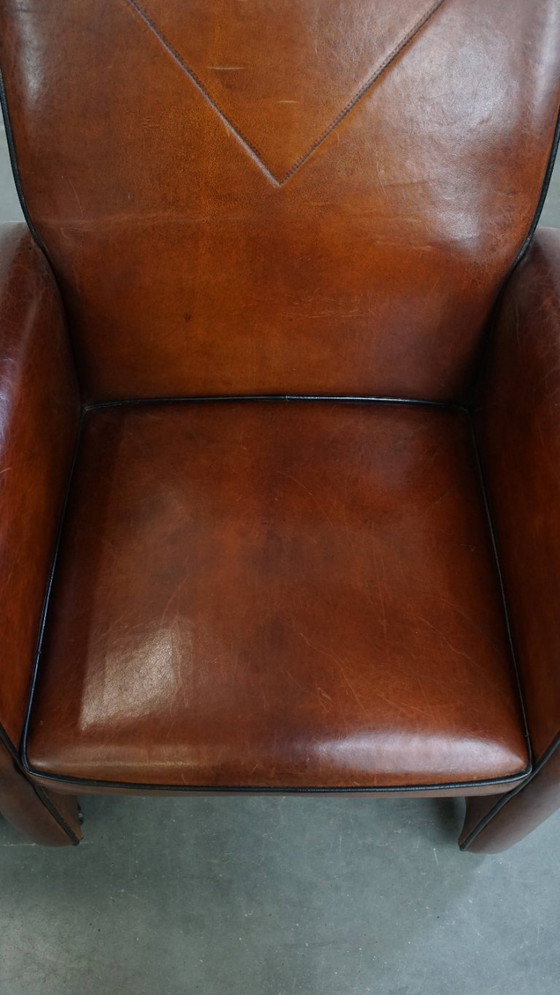 Image 1 of 2 x Vintage schapenleren eetkamerstoel met zwarte biezen op wieltjes