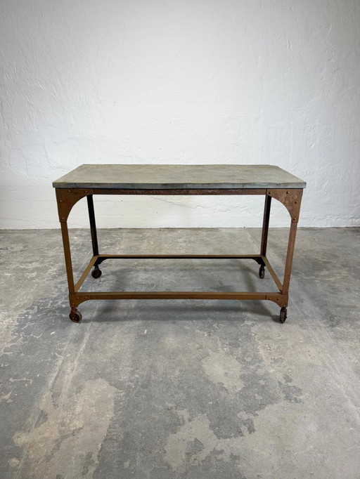 Mesa industrial vintage con tablero de piedra.