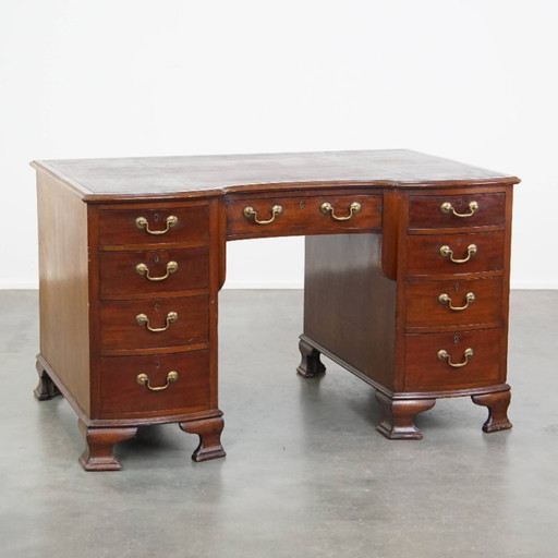 Luxurious and antique English wooden desk from the late 19th century with a leather top and a curved front.