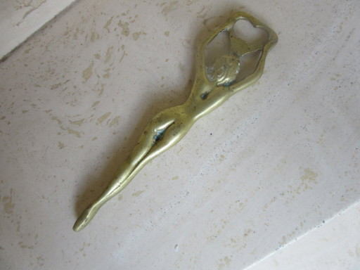 Vintage messing flesopener met pin-up afbeelding van een naakte vrouw (MCM).