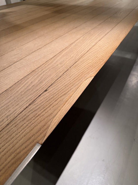 Image 1 of A large oak dining table, designed by Claire Bataille and Paul Ibens