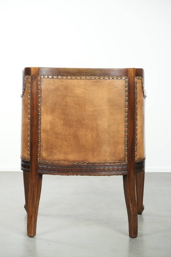 Image 1 of Antique armchair of sheepskin and wood with decorative nails and beautiful woodwork