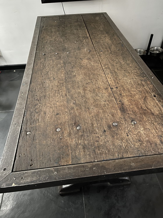 Image 1 of Industriele eettafel van oude werkbank met gietijzer onderstel y gelaste randen