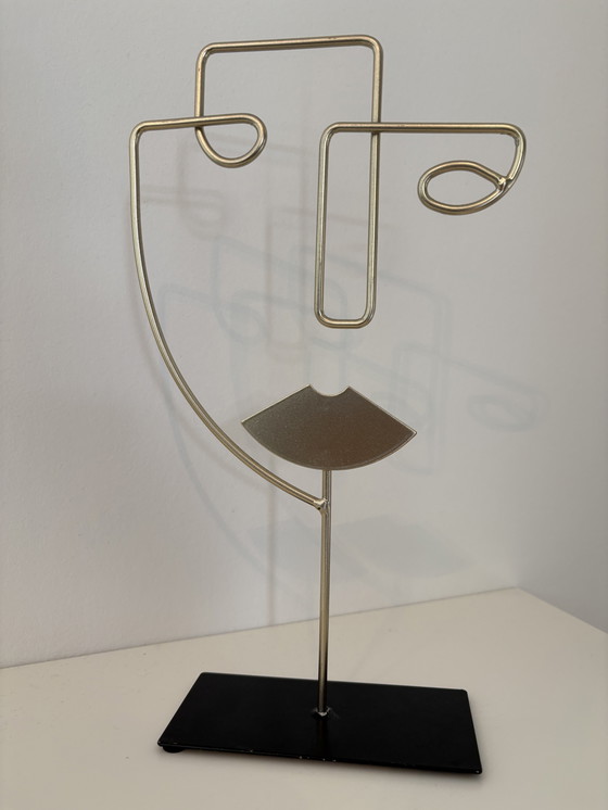 Image 1 of Scultura moderna in filo metallico raffigurante un volto stilizzato, di colore oro