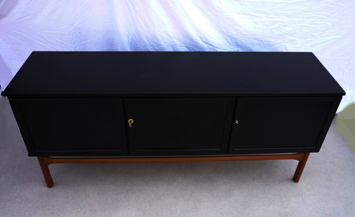 Aparador negro con 3 puertas y 3 cajones.