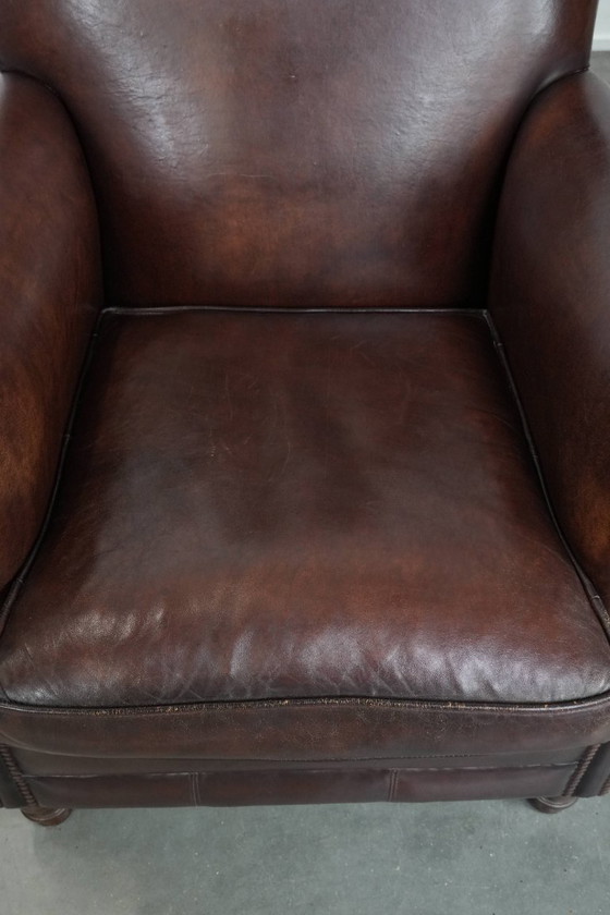 Image 1 of Fauteuil en peau de mouton aux couleurs chaudes et à la finition classique orné de clous décoratifs