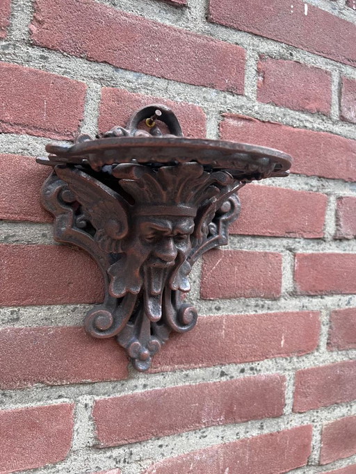 Consola de hierro fundido con cara decorativa