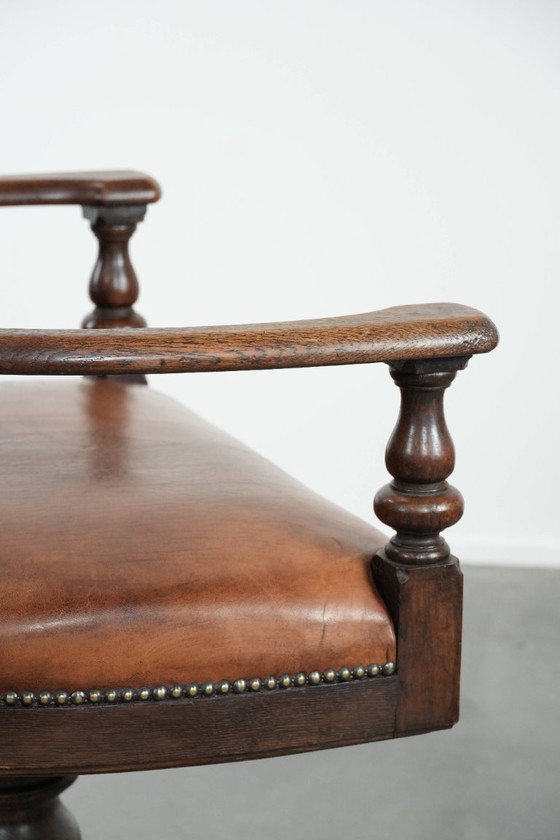 Image 1 of Elegante antieke schapenleren bureaustoel met een zwaar houten frame