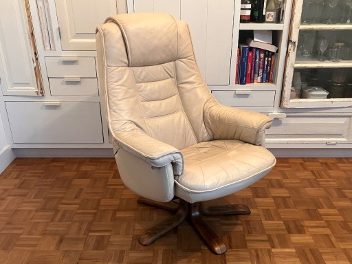 Poltrona girevole vintage in pelle color crema, ideale per rilassarsi negli anni Settanta.